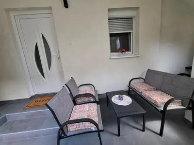 a living room with two chairs and a table at Apartman Mint in Bihać