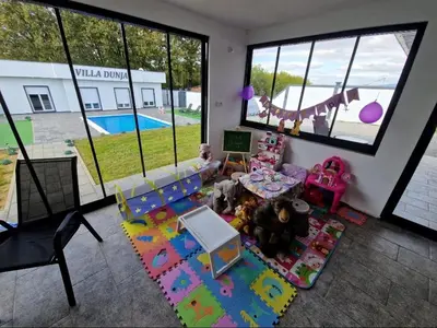 a living room with a view of a play area at Villa Dunja Prijedor in Prijedor