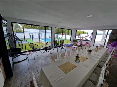a large room with tables and chairs and windows at Villa Dunja Prijedor in Prijedor