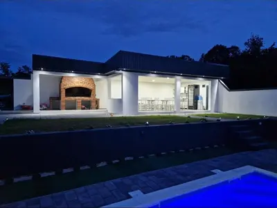a white house with a fireplace in front of it at Villa Dunja Prijedor in Prijedor