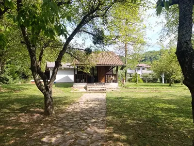 a house in the middle of a field with trees at River Nest in Kulen Vakuf