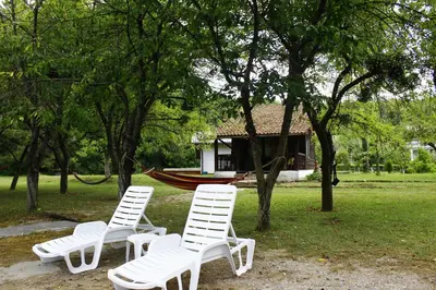 two white chairs sitting in front of a house at River Nest in Kulen Vakuf