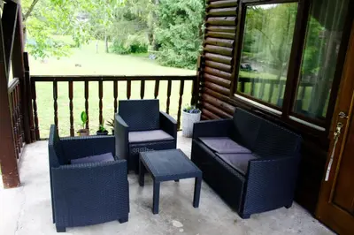 a porch with three chairs and a table and a porch at River Nest in Kulen Vakuf
