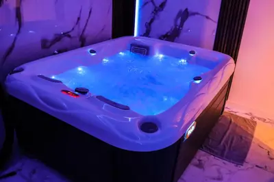 a bath tub with blue water in a room at Om relax in Prijedor