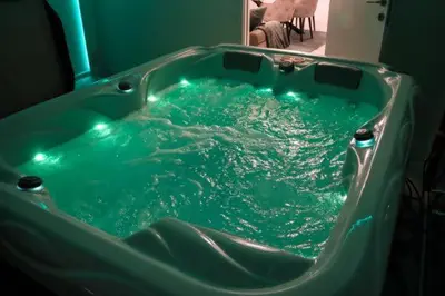 a green tub filled with blue water in a bathroom at Om relax in Prijedor