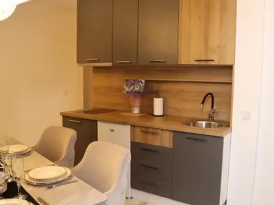 a kitchen with a table and chairs and a sink at Om relax in Prijedor