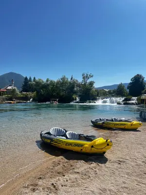 three canoes on the shore of a river at Apartman UnaTesnim in Bihać
