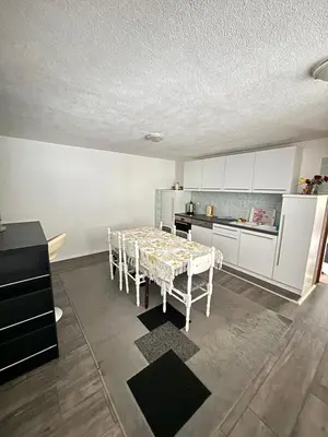 a kitchen with a table with chairs and a refrigerator at Apartman UnaTesnim in Bihać