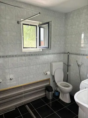 a bathroom with a toilet and a sink and a window at Apartman UnaTesnim in Bihać