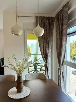 a dining room table with a vase of flowers on it at Apartment Alma in Bihać