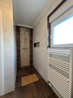 a walk in shower in a bathroom with a window at Apartment Alma in Bihać