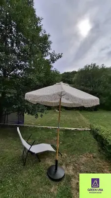 a chair and an umbrella in the grass at Green Una Wooden House in Kulen Vakuf