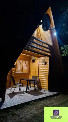 a patio with a table and chairs in front of a house at Green Una Wooden House in Kulen Vakuf
