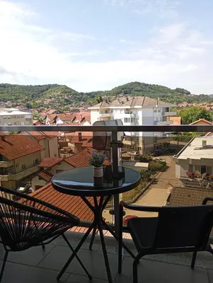 a table and chairs on a balcony with a view at ALEXiS in Modriča