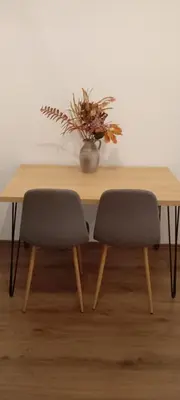 a wooden table with two chairs and a vase of flowers at ALEXiS in Modriča