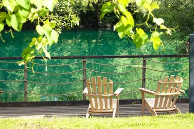 two chairs sitting on a deck with a body of water at Villa Aurelia Wellness in Illidža
