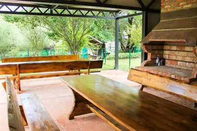 a patio with wooden benches and a table at Villa Aurelia Wellness in Illidža