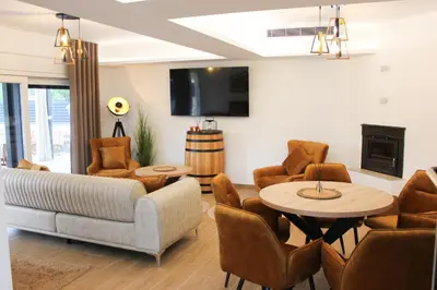 a living room with a couch and a table and chairs at Villa Aurelia Wellness in Illidža