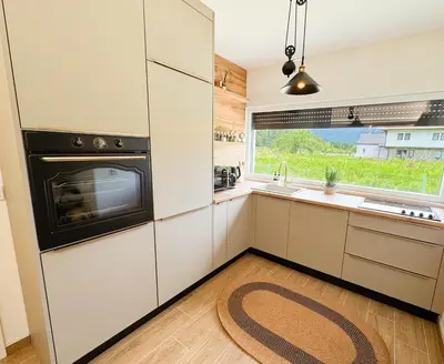 a kitchen with white cabinets and a large window at Villa Aurelia Wellness in Illidža
