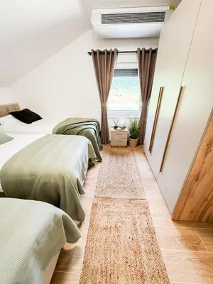 a bedroom with three beds and a window at Villa Aurelia Wellness in Illidža