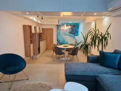 a living room with a blue couch and a table at Apartman TRG, Prijedor in Prijedor