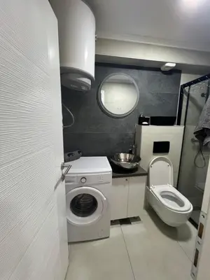 a small bathroom with a washing machine and a toilet at Apartman TRG, Prijedor in Prijedor