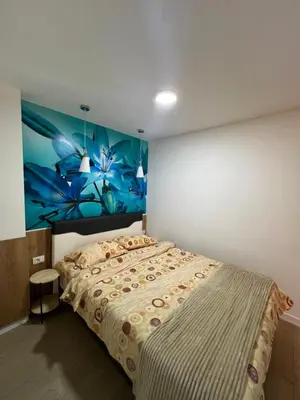 a bedroom with a bed with a painting on the wall at Apartman TRG, Prijedor in Prijedor