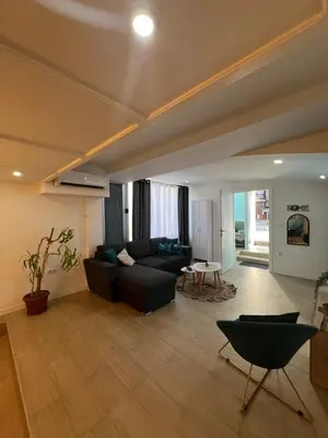 a living room with a black couch and a table at Apartman TRG, Prijedor in Prijedor