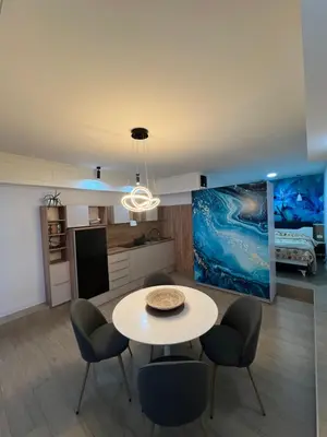 a kitchen and living room with a table and chairs at Apartman TRG, Prijedor in Prijedor