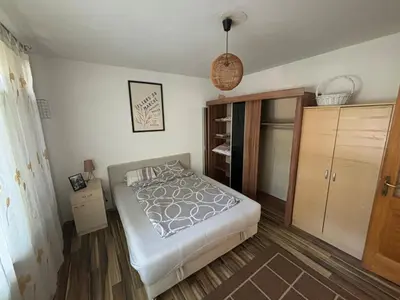 a bedroom with a bed and a wooden floor at Bihac Center Apartment in Bihać
