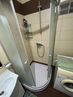 a small bathroom with a shower and a sink at Bihac Center Apartment in Bihać