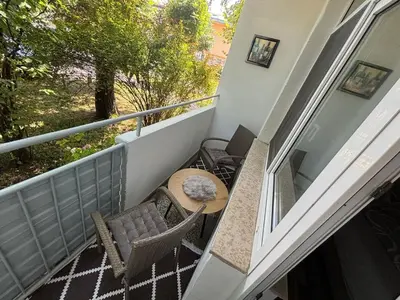 a balcony with a wooden table and chairs and a table at Bihac Center Apartment in Bihać
