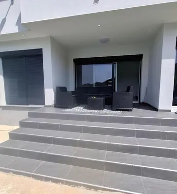 a living room with stairs and a table and chairs at Nature flow Bihac in Otoka
