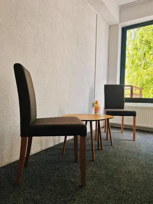 a room with a table and a chair and a laptop at Apartman Alinac in Cazin