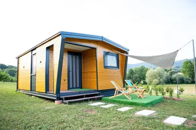 a tiny house in a field with a tent at Seosko Domaćinstvo Protic , Prijedor , Veliko Palančište in Velika Palančište
