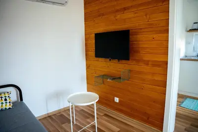 a room with a wall with a tv and a chair at Seosko Domaćinstvo Protic , Prijedor , Veliko Palančište in Velika Palančište