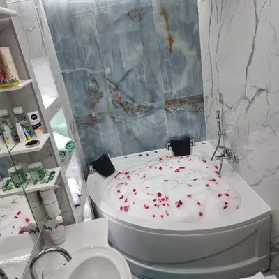 a bathroom with a toilet and a tub with flowers on it at Ramonda Smještaj in Tuzla