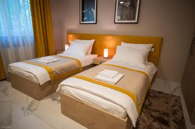 two beds in a hotel room with towels on them at Hotel & Distillery Monogram in Mišići