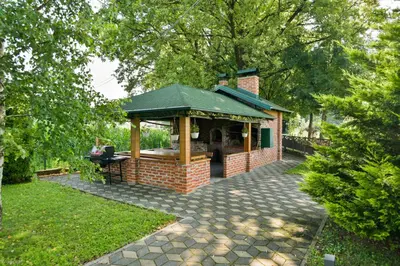 a building with a gazebo in a yard at Hotel & Distillery Monogram in Mišići
