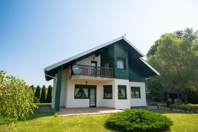 a green and white house with a balcony at Hotel & Distillery Monogram in Mišići