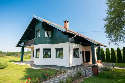 a green and white house in a field at Hotel & Distillery Monogram in Mišići