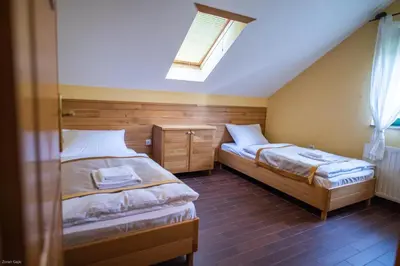 a bedroom with two beds and a skylight at Hotel & Distillery Monogram in Mišići