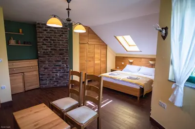 a bedroom with a bed and a table and a chair at Hotel & Distillery Monogram in Mišići