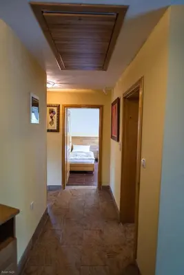a hallway leading to a bedroom with a bed at Hotel & Distillery Monogram in Mišići