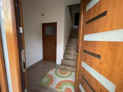 a hallway with a wooden door and a staircase at EDina Apartman in Bihać