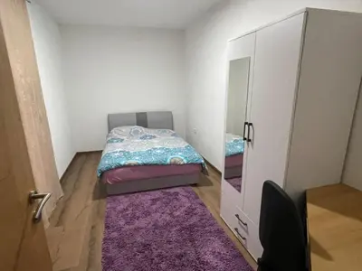 a small bedroom with a bed and a cabinet at EDina Apartman in Bihać
