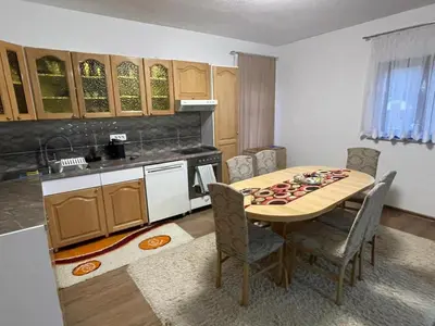 a kitchen with a wooden table and a kitchen with a table and chairs at EDina Apartman in Bihać