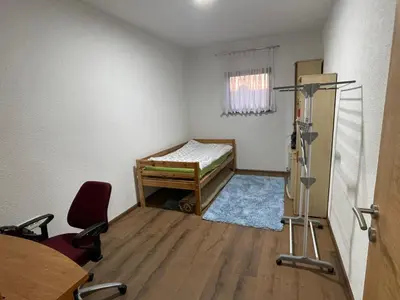 a room with a bed and a desk and a chair at EDina Apartman in Bihać