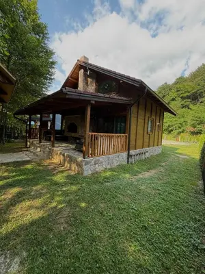 a small building with a porch on a grass field at UNA Dream in Bihać
