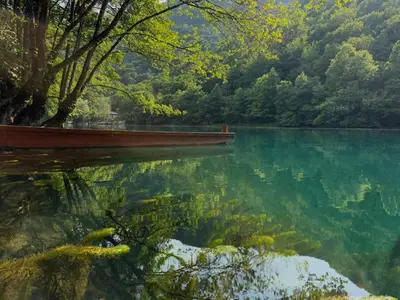 a view of a lake with a boat in the water at UNA Dream in Bihać